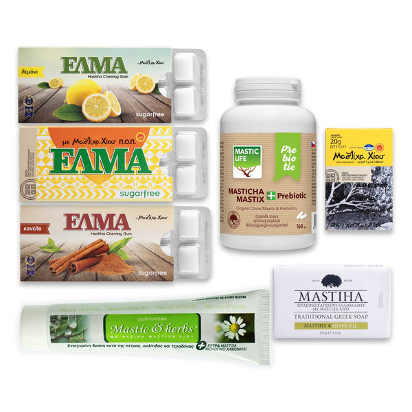 A collection of products from the Mastic 'Life with Mastic' Box, including Mastic+ Prebiotic capsules, large raw mastic crystals, traditional Greek soap, mastic toothpaste, and ELMA mastic chewing gum in three flavors.